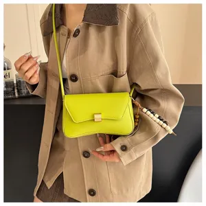 Primo piano dettagliato della borsa a tracolla giallo neon con ciondolo in perline di legno.