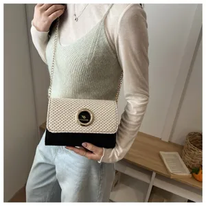 Détail de sac bandoulière en paille chic avec fermoir métallique tendance et chaîne.