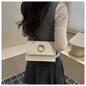 Sac bandoulière femme en paille tressée et cuir avec fermoir anneau métallique et chaîne.