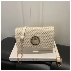 Vue détaillée du sac à bandoulière en paille tissée pour femme avec sangle chaîne dorée.