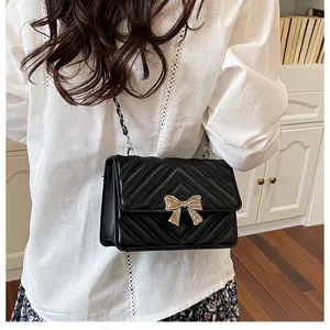 Stylish black quilted shoulder bag for women with chic metal bow and chain strap design.