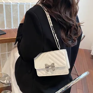 Chic white quilted chain shoulder bag featuring elegant bow decor for casual daily wear