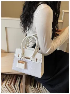 Detailed lifestyle shot showcasing the elegant white structured shoulder bag with chic hardware.