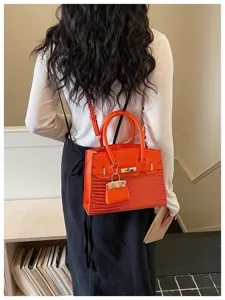 Orange crocodile pattern handbag, stylish shoulder cross body bag with top handle and lock.