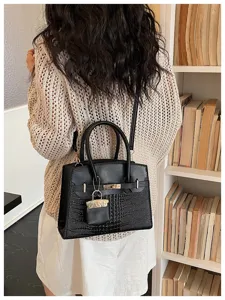 Black crocodile pattern shoulder bag for women, featuring a chic lock pendant and sturdy handles.