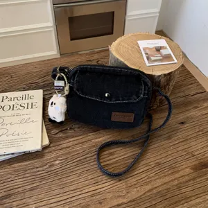 Λεπτομέρεια τσάντας χιαστί denim, υφασμάτινη πλυμένη υφάσματα με χαριτωμένο βελούδινο μενταγιόν.