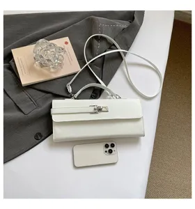 Vista detallada de un elegante bolso de hombro blanco con cierre metálico y correa.