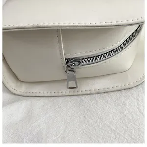 Detailansicht der minimalistischen weißen Achseltasche mit glattem Reißverschluss und Nähten.