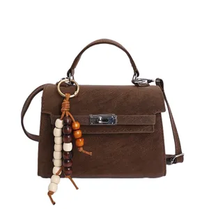 Brown top-handle messenger bag, chic textured leather shoulder bag with chic wooden bead charm.