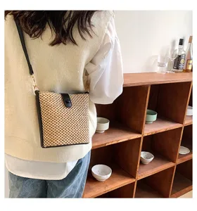 Summer straw woven crossbody bag detail, casual small shoulder bag with black leather trim.