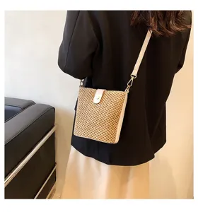 Detail view of the stylish summer straw woven crossbody bag, featuring chic leather flap and strap.