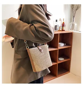 Summer straw woven crossbody bag for women, stylish bucket shoulder handbag with PU leather trim.