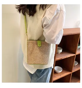 Stylish summer straw bucket bag for women, casual woven crossbody bag with green leather trim.