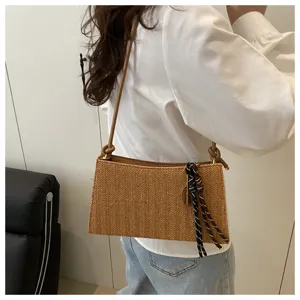 Vista detallada del bolso de hombro tejido para mujer, elegante bolso de paja marrón.