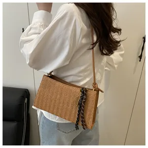Vista detallada del elegante bolso de hombro tejido con bonito colgante para uso diario chic.