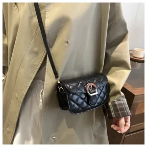 Black quilted crossbody bag detail showing the unique wooden buckle and strap.