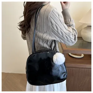 Borsa a tracolla minimalista in vernice nera con ciondolo pon pon soffice da donna autunno inverno.