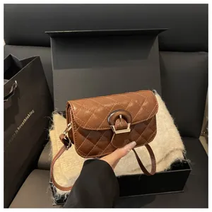 Close-up detail of brown quilted shoulder bag with unique wooden buckle and strap.