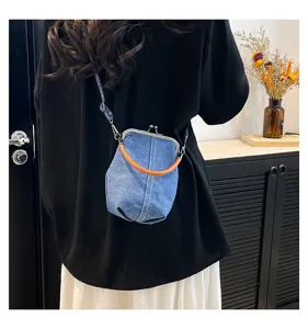 Vue détaillée du sac bandoulière en denim, design rétro à fermoir métallique et poignée marron.
