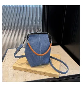 Sac bandoulière élégant en denim avec fermoir baiser et poignée en cuir, détail vintage.