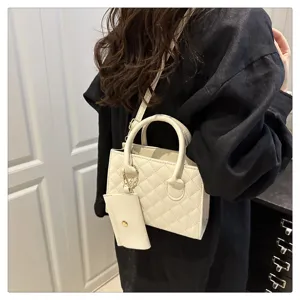 White quilted shoulder bag detail, elegant fashion handbag worn on model daily.