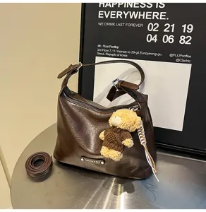 Detail view of dark brown PU leather hobo shoulder bag with cute teddy bear charm