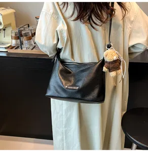 Black soft leather underarm shoulder bag with metal tag and cute bear pendant.