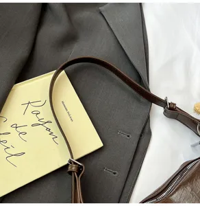 Brown leather shoulder bag detail, stylish underarm bag close-up, premium texture everyday casual accessory