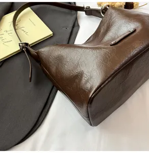 Brown leather underarm bag detail shot, chic style, versatile single shoulder handbag for women.