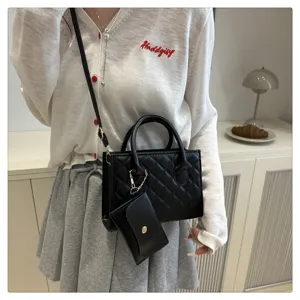 Close-up detail of black quilted shoulder bag featuring premium texture and coin purse charm.