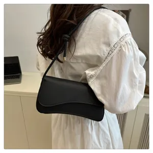 Detailed view of the black minimalist shoulder bag worn on shoulder, stylish daily accessory.