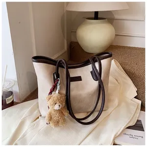 Detailed view of the vintage oil wax leather tote bag with cute bear pendant and handles.