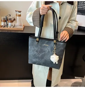 Grote grijze shopper tas detailweergave, casual schoudertas met pluizige hanger voor dames.