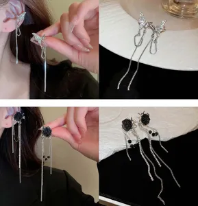Dettaglio di orecchini a clip con napphe a farfalla in strass e rosa nera, stile gotico.