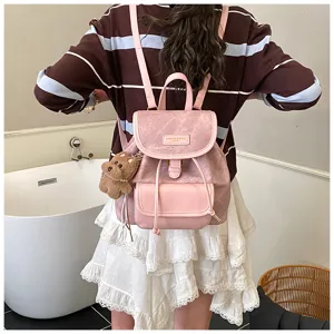 Detailansicht des stilvollen Kunstleder-Rucksacks mit Kontrastdesign und süßem Bären-Anhänger.