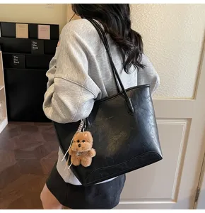 Vista detallada de un bolso tote negro de piel sintética con osito para el trabajo.
