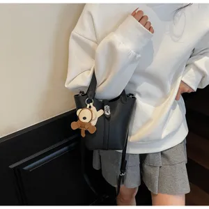 Bolso tipo cubo de piel sintética con asa superior y correa, diseño casual muy elegante.