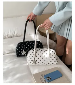 Cute polka dot pillow bag for women, stylish shoulder handbag with star pendant charm detail.