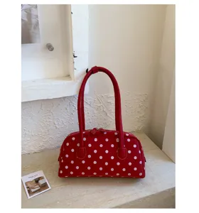 Detail view of the red polka dot handbag, stylish shoulder bag and pillow bag design.