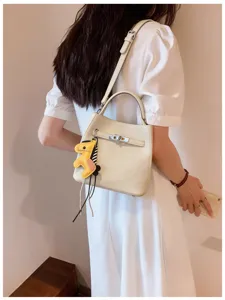 Elegante Beuteltasche aus Litschimuster-Leder mit Tragegriff und Drehverschluss-Design.