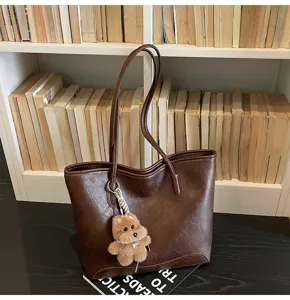 Bolso tote de cuero PU marron con bonito colgante de cachorro de peluche para mujer.