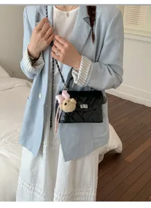 Detailed view of chic quilted women shoulder bag with cute bear charm and chain strap style.
