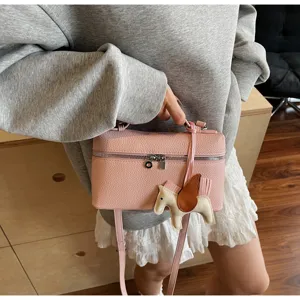 Detalle de bolso bandolera de cuero rosa, lindo dije de caballo alado, elegante bolso casual.