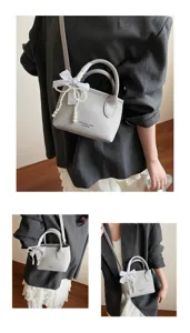 Borsa a secchiello grigia elegante con fiocco bianco e perle, ideale per ogni occasione.
