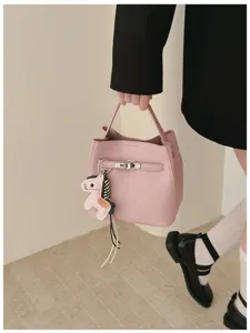 Rosa Litschimuster Eimer Handtasche Detailansicht mit Metallschloss und niedlichem Pferd Anhänger.