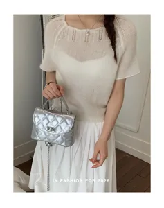 Silver quilted shoulder bag with metal chain strap and turn-lock closure. Trendy detail view.