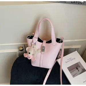 Bolso cubo rosa con patron litchi con correa cruzada y bonito colgante para mujer detalle.