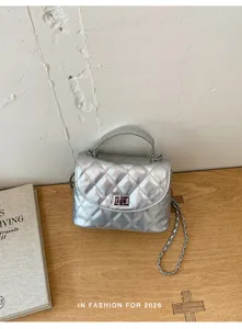 Silver quilted handbag detail showing stylish metal chain strap and turn-lock closure.