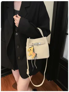 Beige Eimer Handtasche aus Leder mit Schultergurt und einem niedlichen Pferdeanhänger.