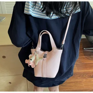 Bolso cubo de cuero con grano lichi rosa para mujer, elegante bolso cruzado con lindo dije de oso